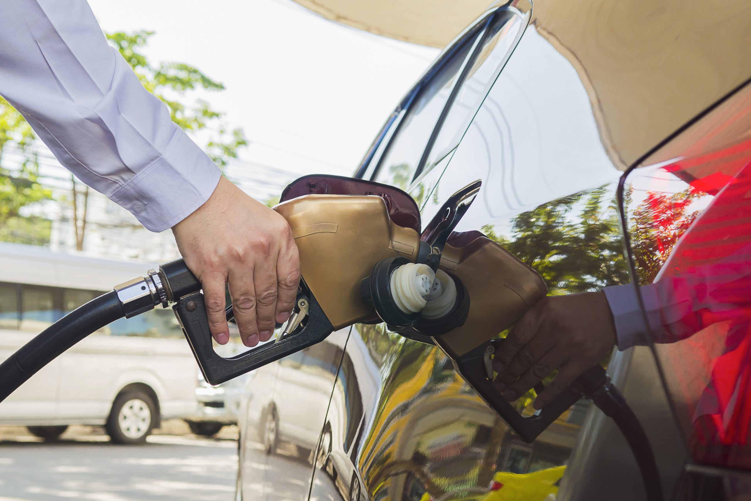 Man putting gasoline fuel into his car in a pump gas station